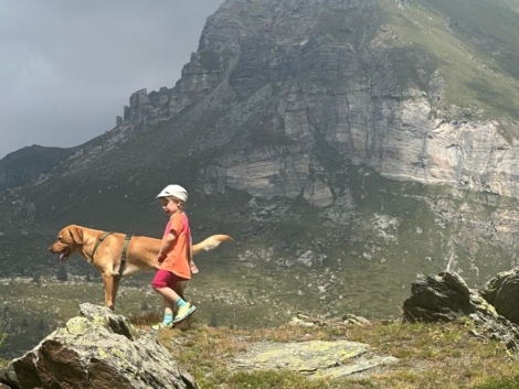 A child with his dog hiking in the Alps during a family and pet friendly vacation at Maison Gorret